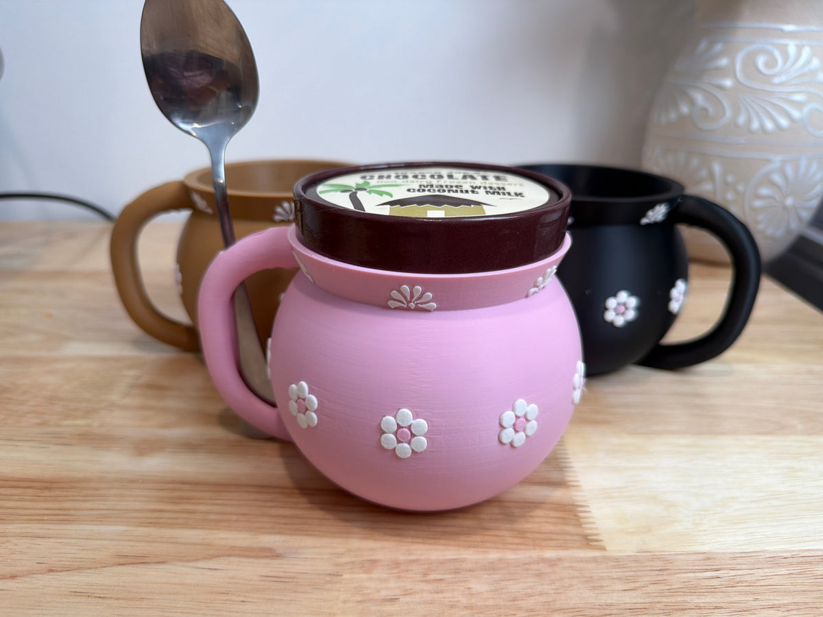 Pink Jarrito holder with an ice cream pint and spoon in the handle slot