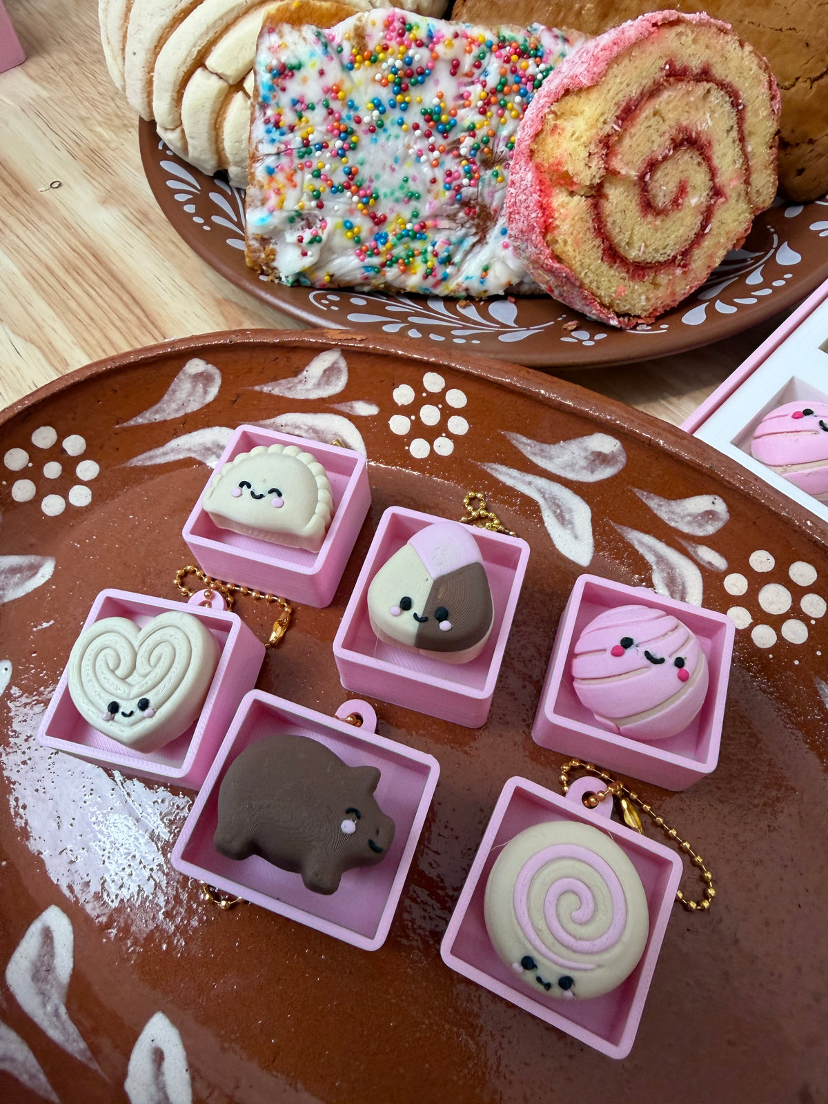 Concha, puerquito, oreja, spiral roll, polvoron and empanada clickers in individual pink boxes