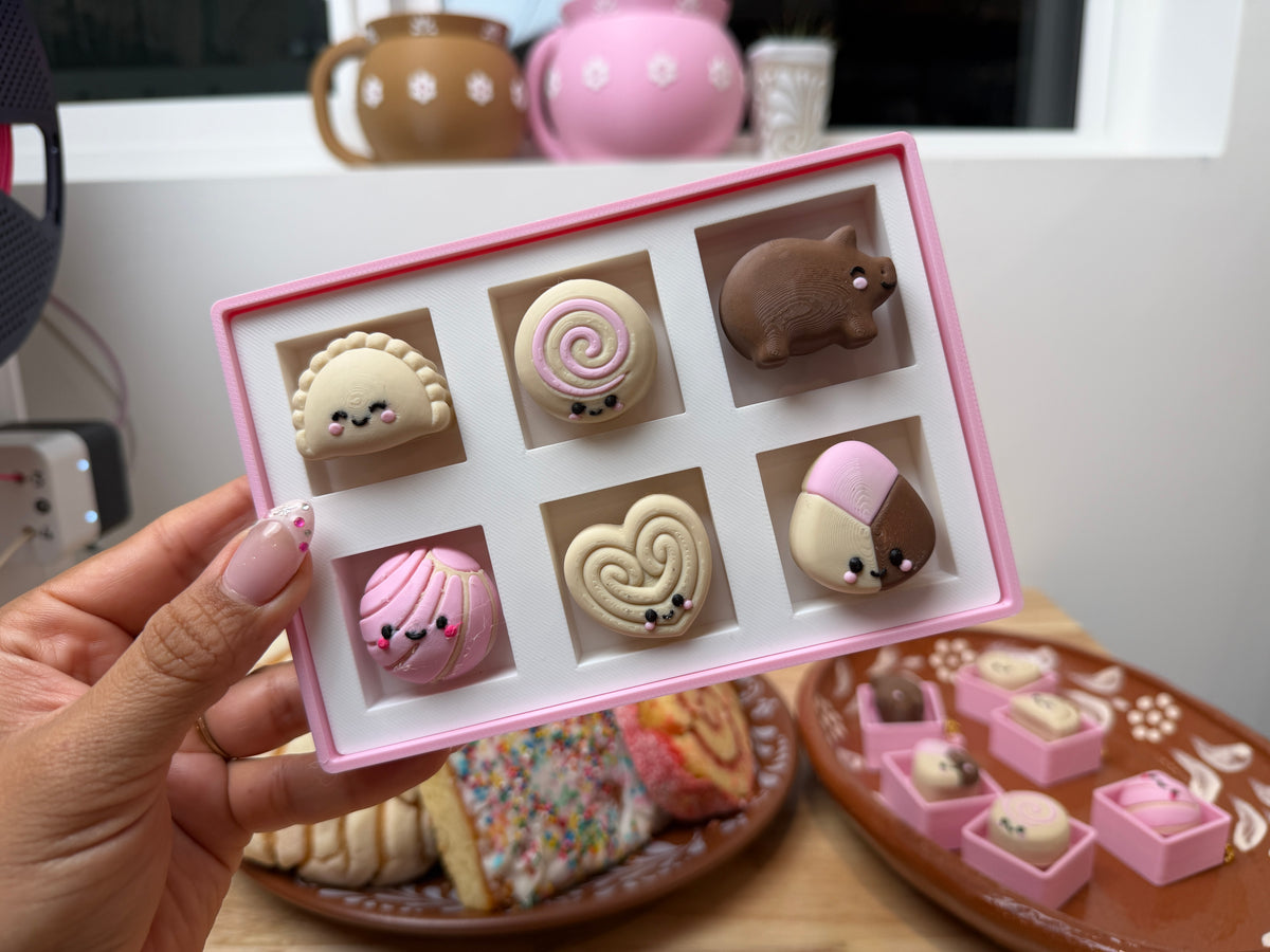 Six kawaii pan dulce clickers in a white insert inside the pink bakery box